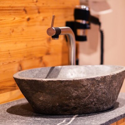 Dettagli eleganti come questo lavabo in pietra sottolineano il design moderno della nostra area benessere.