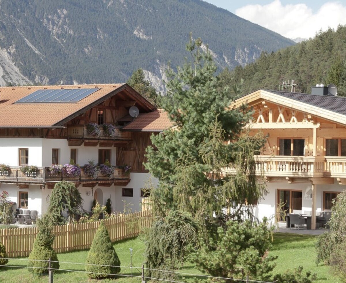 Gli affascinanti appartamenti in stile alpino tradizionale, circondati da un verde giardino e da un pittoresco scenario montano.