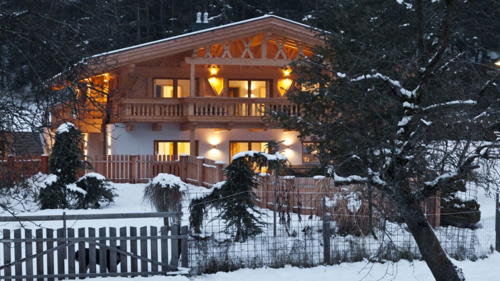 L'accogliente edificio di appartamenti illuminato di sera, immerso in un suggestivo paesaggio invernale innevato.