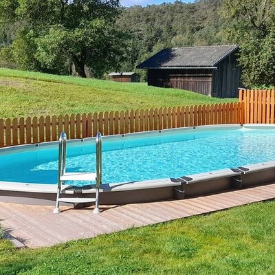 Un'invitante piscina all'aperto nel curato giardino degli appartamenti, circondata da prati verdi.