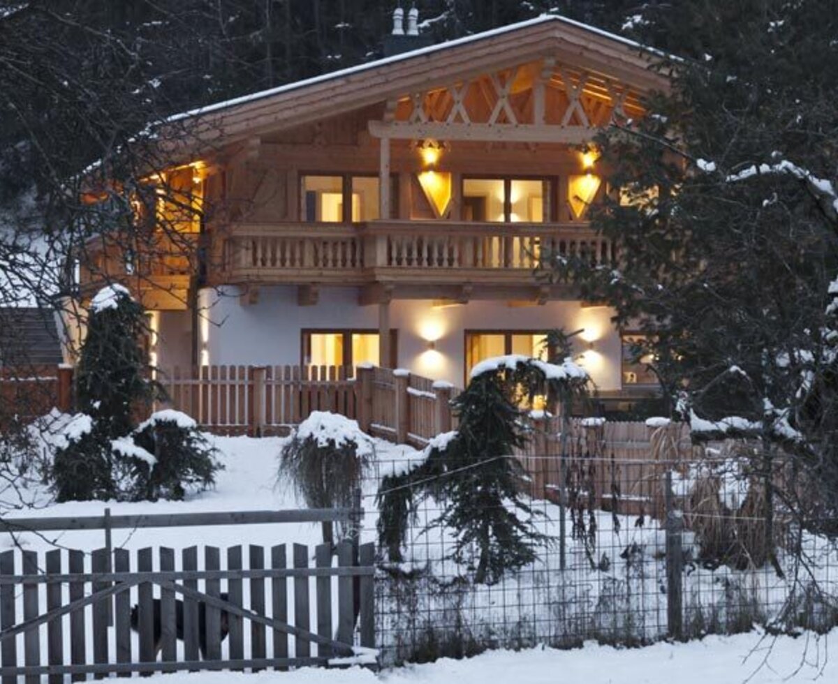 L'invitante edificio degli appartamenti in un paesaggio invernale innevato, calorosamente illuminato all'imbrunire.