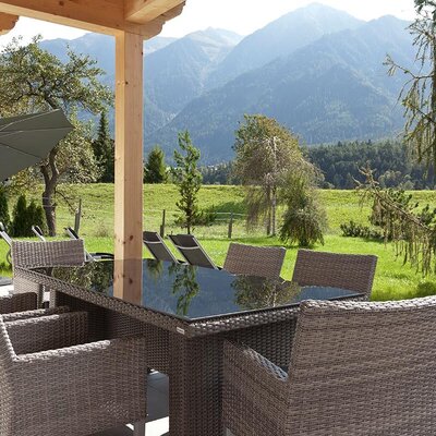 L'invitante terrazza dell'appartamento offre un'accogliente area pranzo all'aperto, lettini e una splendida vista sulle montagne.