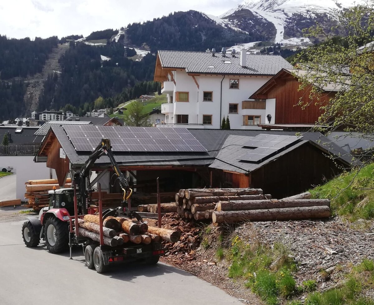 L'agriturismo attivo con la tradizionale lavorazione del legno sullo sfondo di montagne innevate.