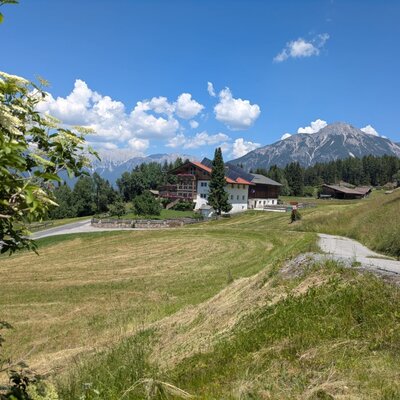 Il maso in un ambiente rurale con ampi prati e vista sulle montagne.