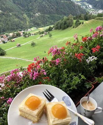 Il balcone dell'agriturismo offre una vista panoramica sulle colline verdeggianti e sulle montagne, ideale per gustare un caffè.