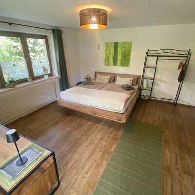 Un'accogliente camera da letto nell'agriturismo con un invitante letto matrimoniale in legno, arredi eleganti e caldi accenti di colore.