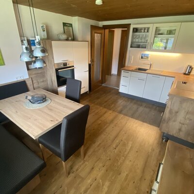 La cucina completamente attrezzata dell'agriturismo, dotata di un'accogliente zona pranzo, caldi dettagli in legno e moderni elettrodomestici.
