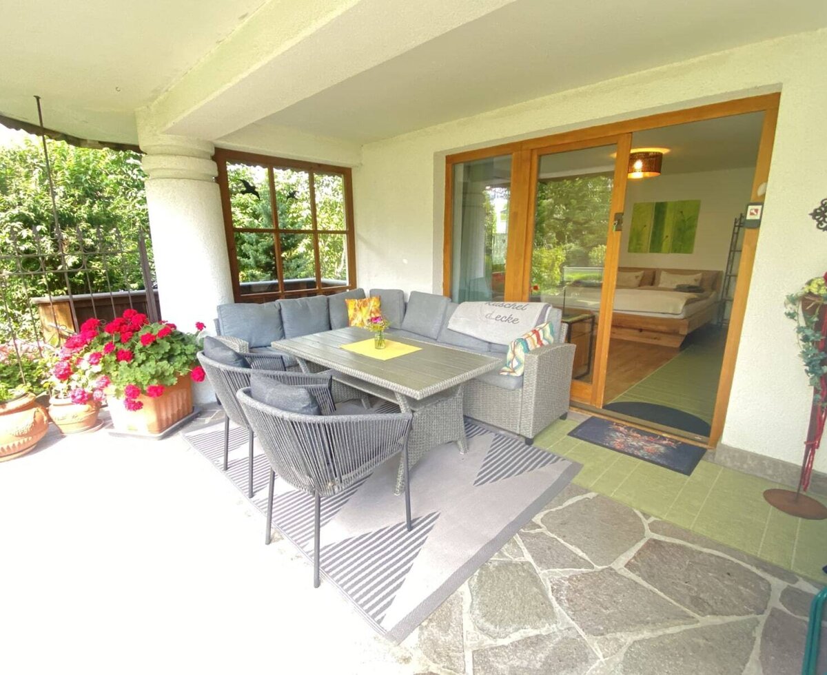 L'invitante terrazza dell'agriturismo con una comoda area salotto, fiori vivaci e accesso diretto alla camera da letto.