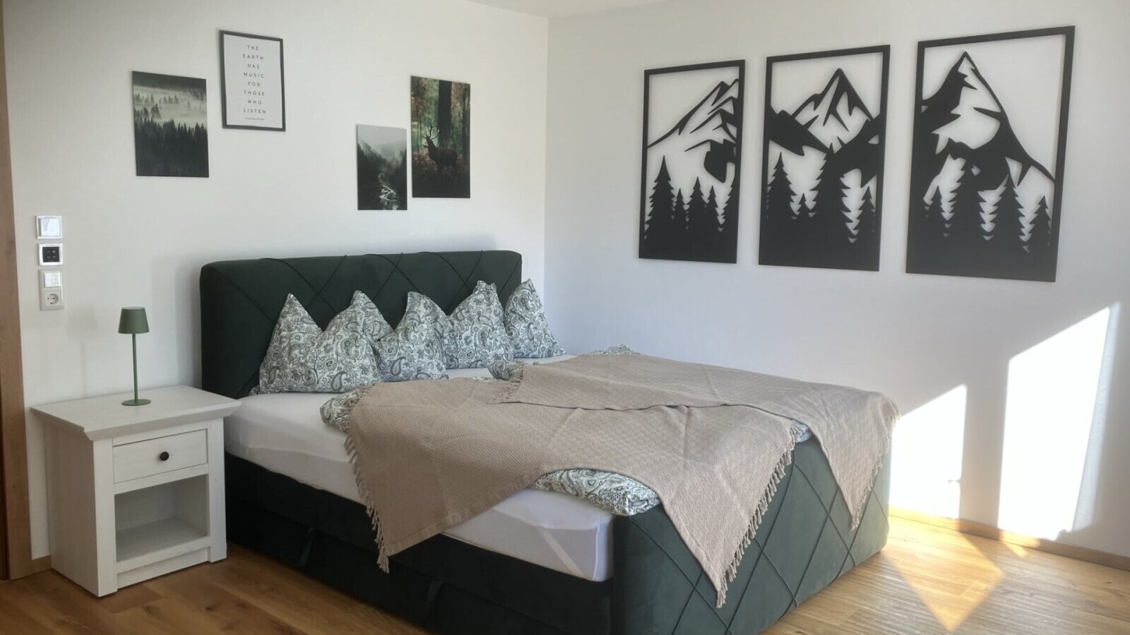 Un'accogliente camera doppia del bed and breakfast con un comodo letto a sommier, eleganti decorazioni murali e un luminoso pavimento in legno.