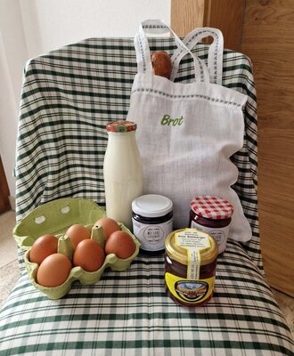 Prodotti freschi della fattoria, inclusi uova, latte, pane e marmellata dalla fattoria.