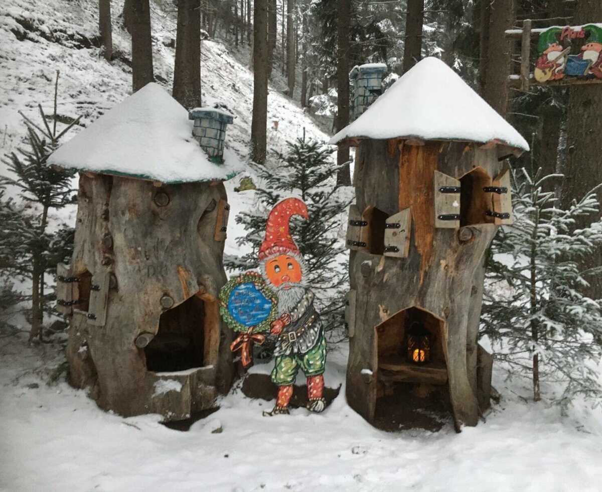 Casette da gioco decorative a forma di tronco d'albero con neve e uno gnomo nel bosco del Bauernhof.