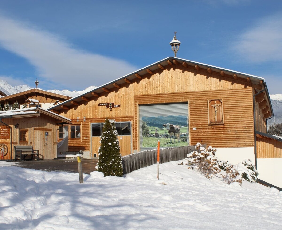 L'esterno degli Ap­par­te­ments in inverno, con il negozio di Pauli e le montagne innevate sullo sfondo.