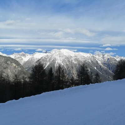 Vista invernale sulle montagne innevate e una pista da sci dal Bauernhof.