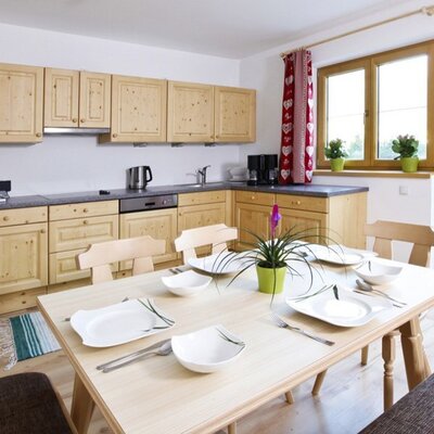 Cucina componibile in abete rosso massiccio con piano cottura elettrico, frigorifero, forno, microonde, macchina per il caffè, tostapane, lavastoviglie, bollitore, affettatrice; stoviglie e bicchieri in quantità sufficiente