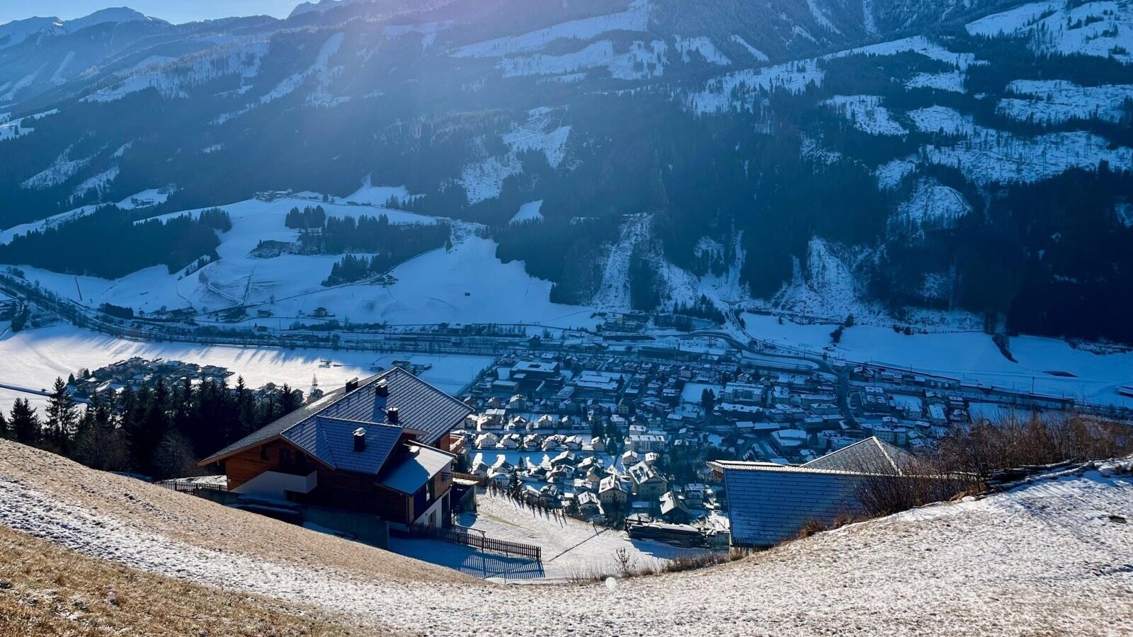 Vista dalla fattoria sul paesaggio montano innevato e sulla valle con il paese.