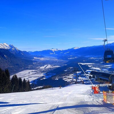 Pista da sci Oberperfuss con cabinovia, che offre una vista panoramica sulla valle innevata e sulle montagne circostanti.