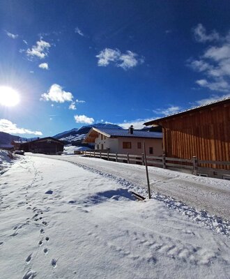 L'idilliaco agriturismo circondato da un suggestivo paesaggio invernale innevato sotto un cielo limpido.