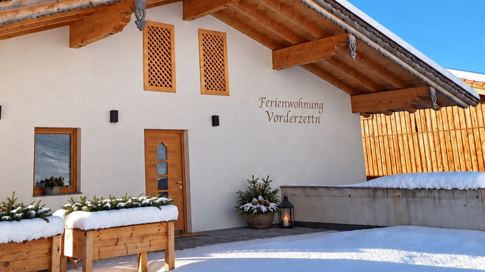 L'accogliente ingresso innevato dell'agriturismo sotto un cielo limpido e azzurro.