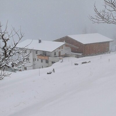 Un idilliaco agriturismo immerso in un profondo paesaggio invernale innevato.
