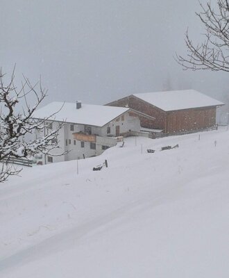 Un idilliaco agriturismo immerso in un profondo paesaggio invernale innevato.