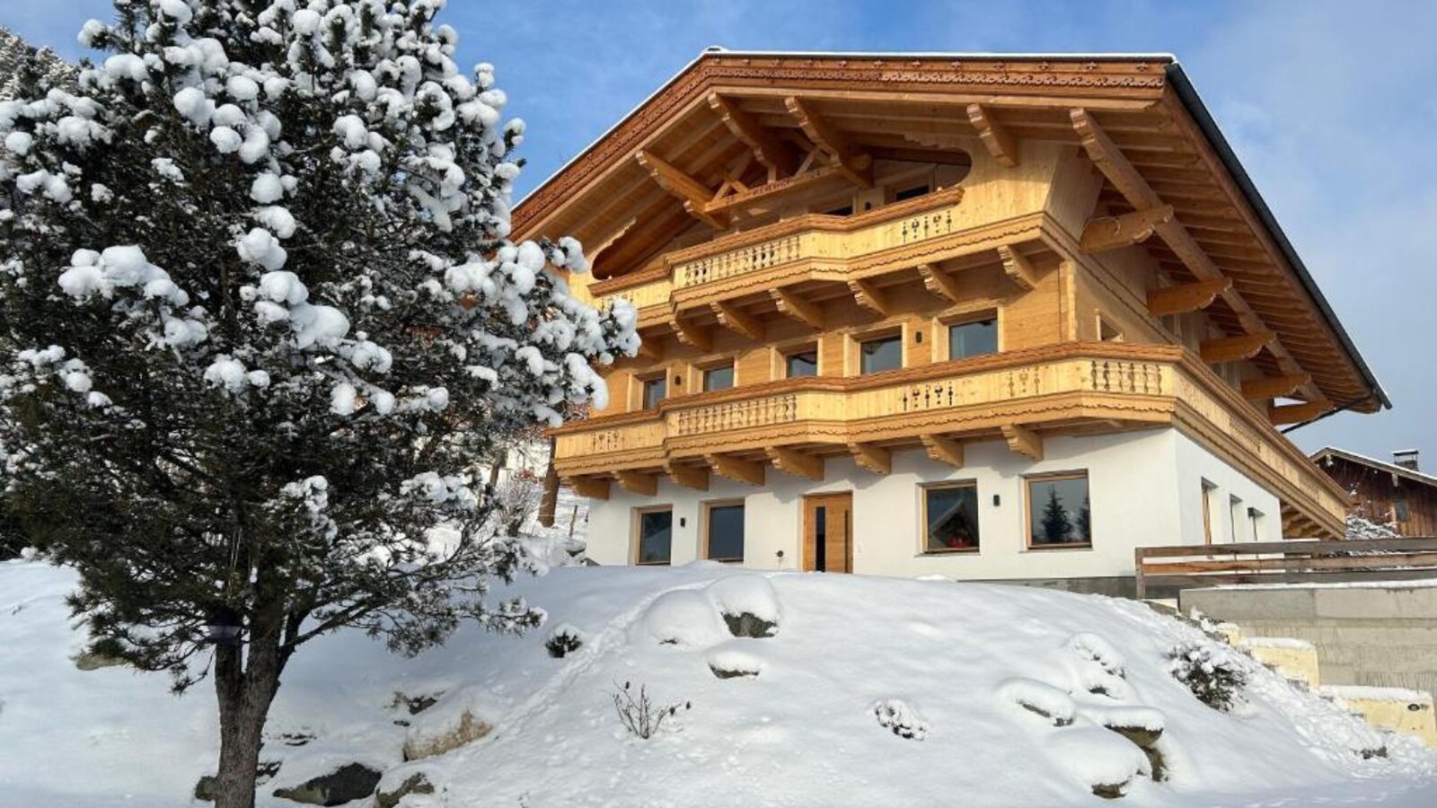 Esterno del Bauernhof in inverno, con facciata in legno, balconi e ambiente innevato.