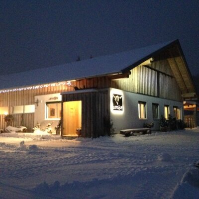Gli accoglienti appartamenti immersi in un suggestivo paesaggio invernale innevato con luci serali.