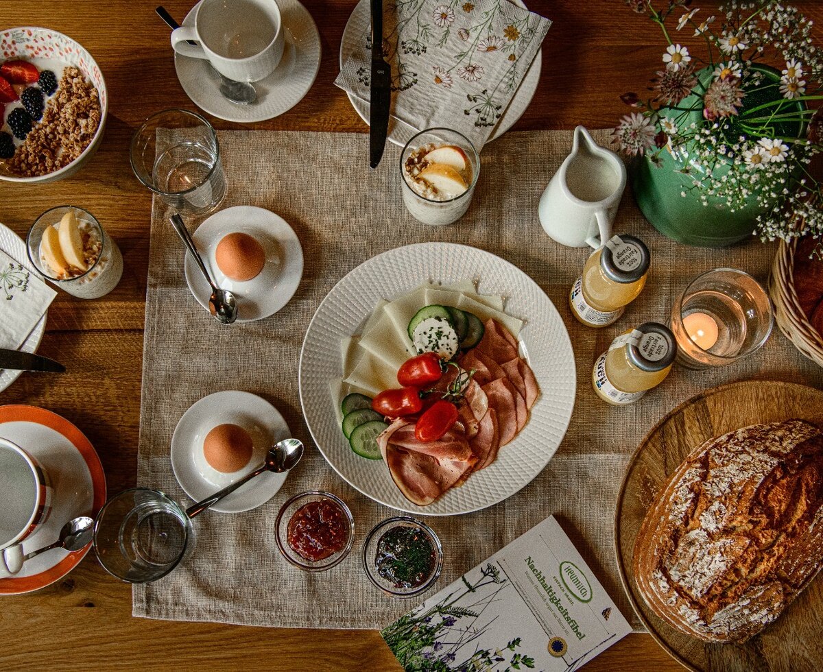 Tavolo della colazione nell'agriturismo con uova, affettati, formaggio, muesli, pane e bevande.